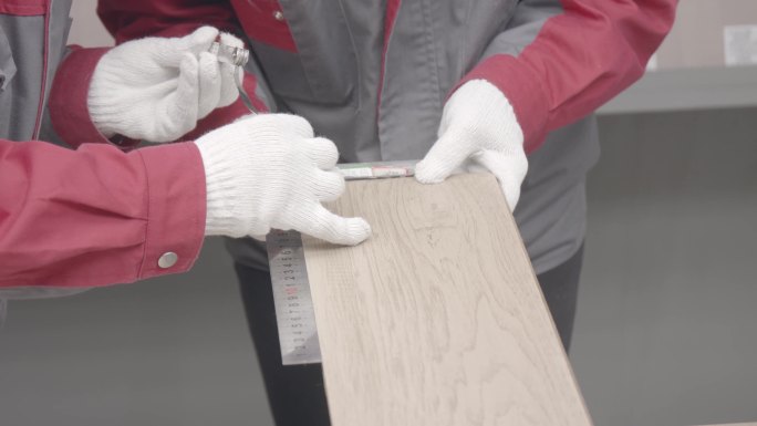工人用尺子测量木板板材