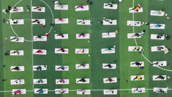 航拍妇女户外体育运动场习练瑜伽健身