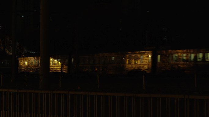 漆黑的晚上，城市昏暗的路灯，夜景绿皮火车