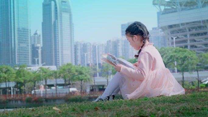 坐在草地上看书的小女孩