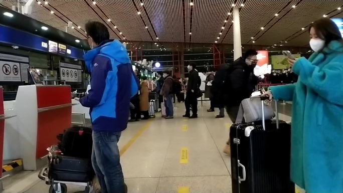 机场候机厅正在等候办理行李托运手续的乘客