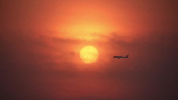 黎明日出时分民航飞机飞过太阳凌日剪影