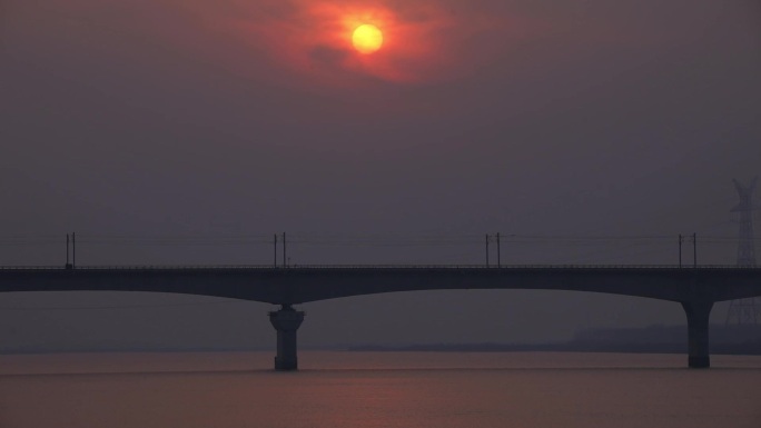 货车火车在美丽夕阳时分驶经松花江铁路桥