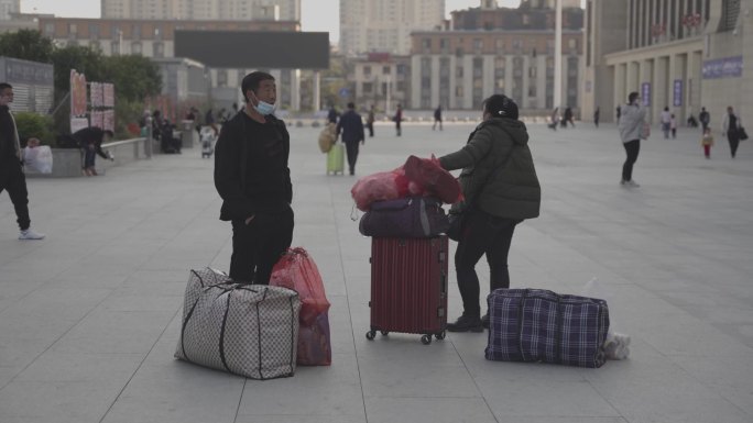 南昌火车站东外等待行人旅客拿着行李