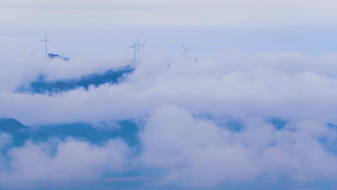 山上风力发电机在飞腾的云雾中旋转