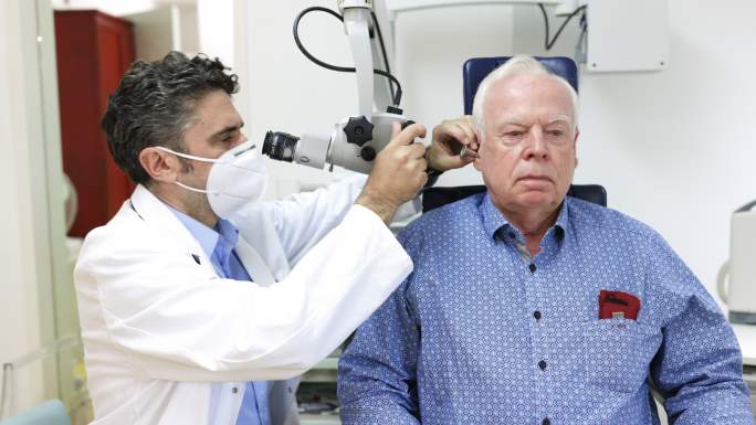 耳鼻喉科医生检查一位老人的耳朵