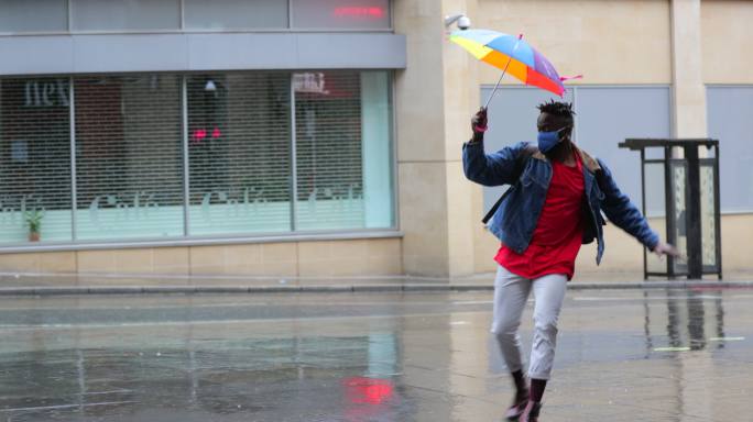 男子手持雨伞在雨中跳舞
