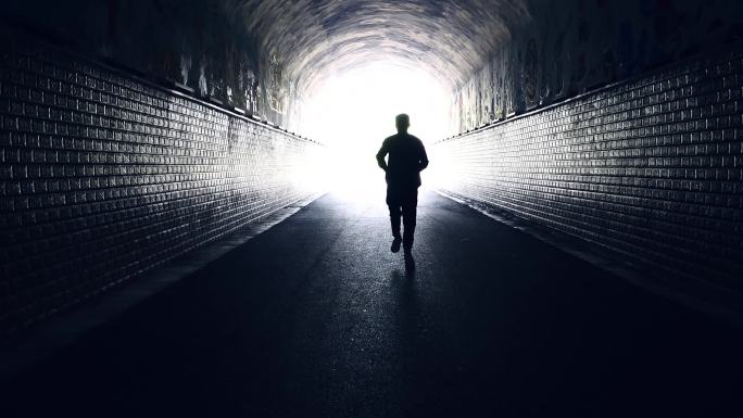 男运动员跑过一个漆黑的隧道