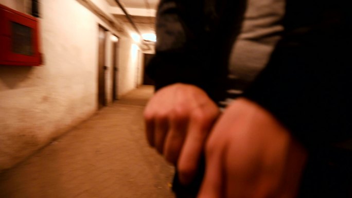 一名警察独自在大楼地下室追捕罪犯。