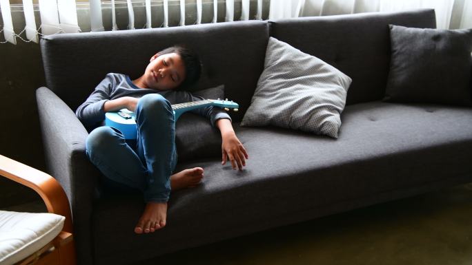 懒惰的男孩躺在沙发上