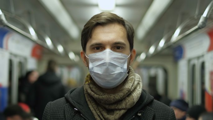 地铁客运列车内戴着口罩的男子