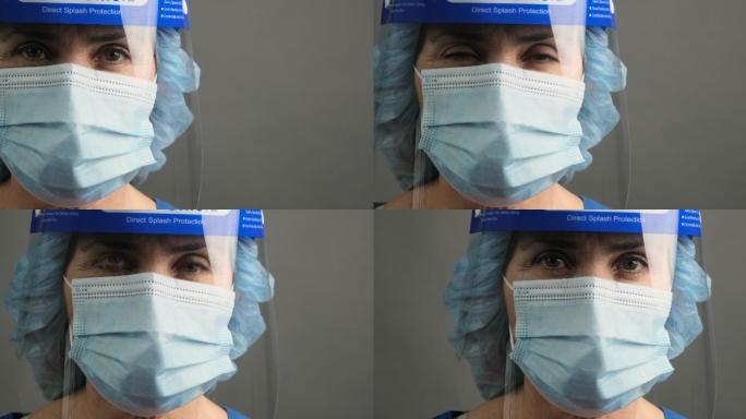 精疲力竭的医护人员戴着口罩和面罩看着镜头