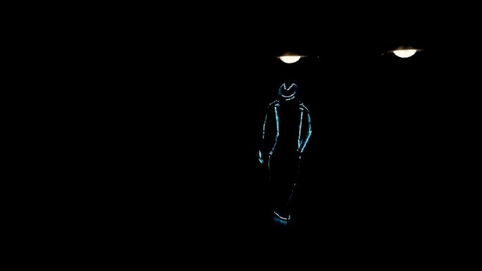 一个穿着LED套装的男人在黑暗中跳舞