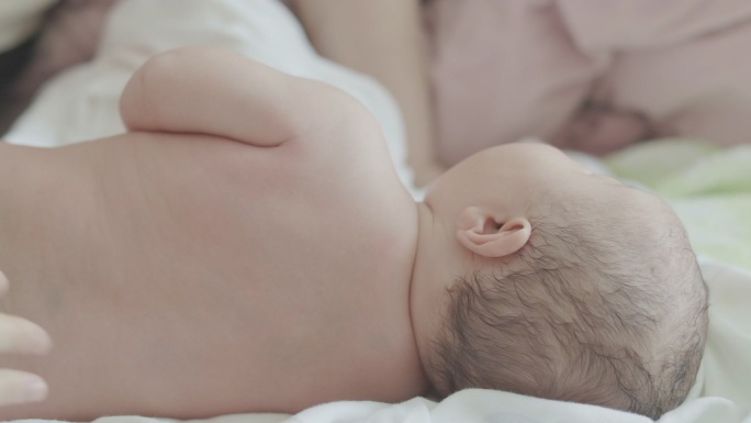 新生儿做身体护理，擦拭爽身乳