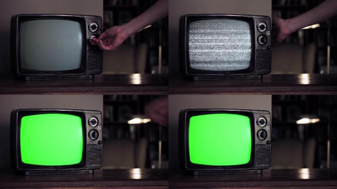 用手开一台绿色屏幕的旧电视机。