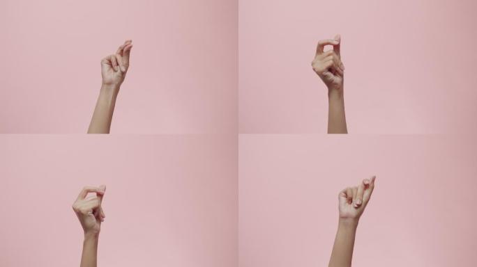 女性的手在粉色工作室背景上做手势