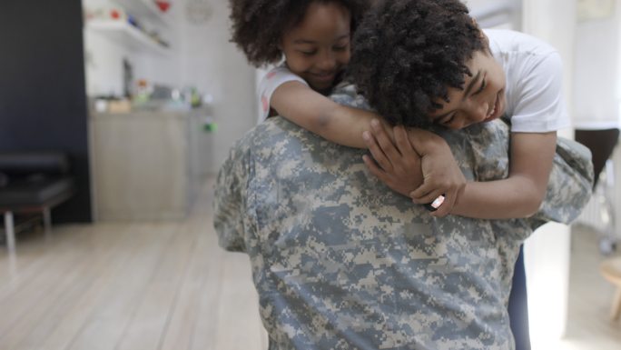 男士兵回到家里，他的孩子们拥抱着他