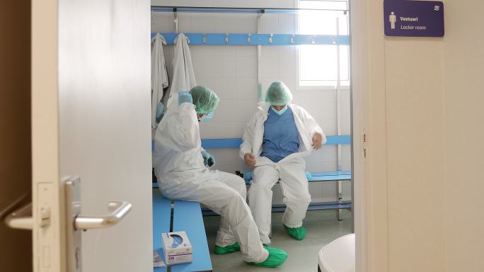 两名医生在医院更衣室脱下防护装备