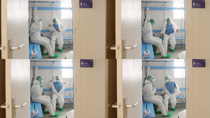 两名医生在医院更衣室脱下防护装备