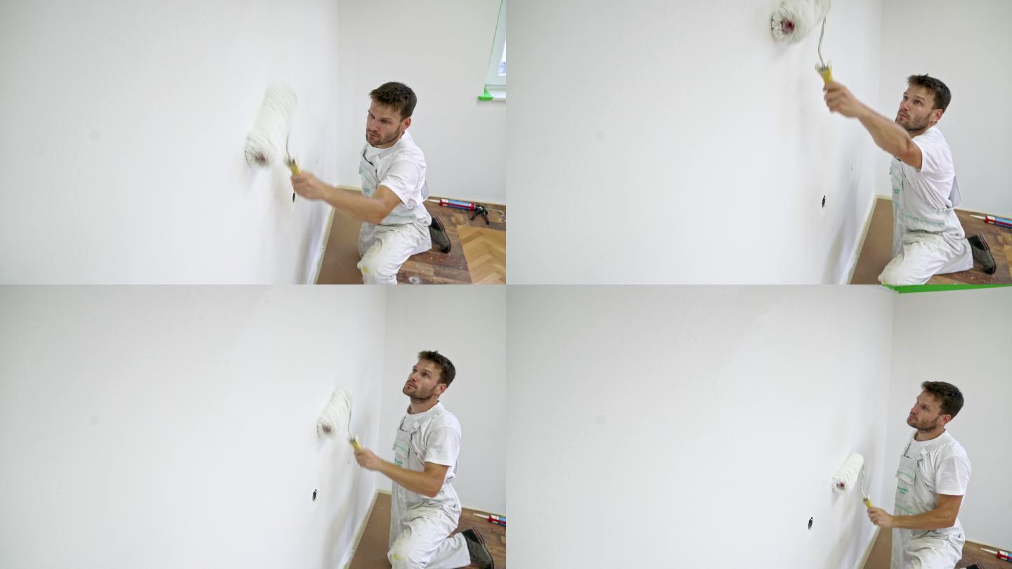 专业油漆工使用油漆辊将墙壁涂成白色