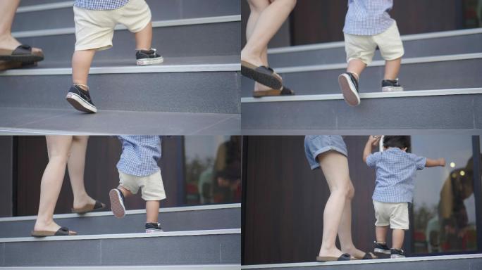小男孩牵着妈妈的手走在楼梯上