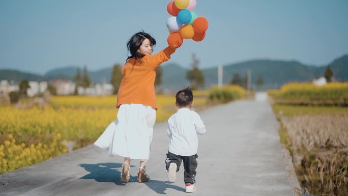 唯美妈妈陪小孩田间奔跑亲子活动高兴的小孩