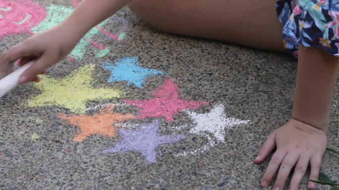 姐妹们在车道上用粉笔画画