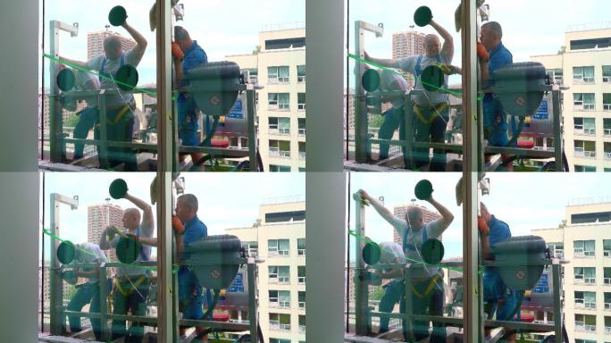 一队蓝领工人正在更换办公楼里一扇破碎的窗户