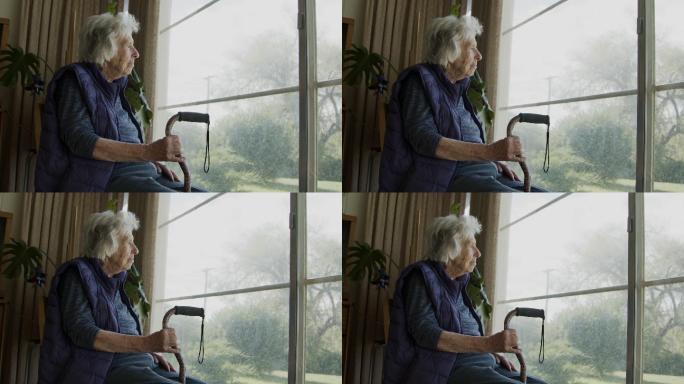 老年妇女在室内看着窗外的广角镜头