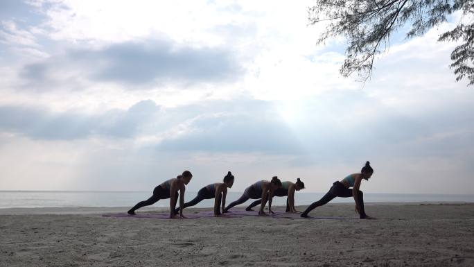 一群女人在海滩上做瑜伽