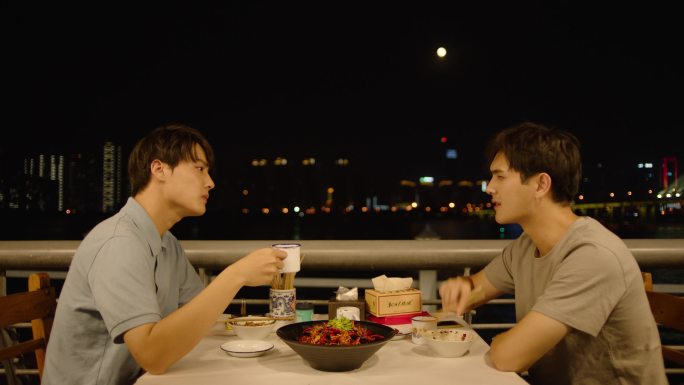 两名青年在江边夜宵摊吃夜宵