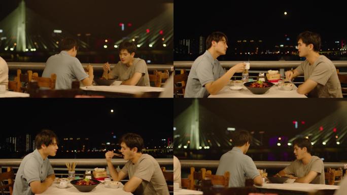 两名青年在江边夜宵摊吃夜宵