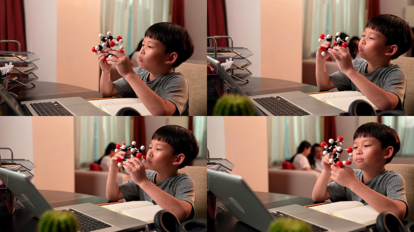男孩在线学习时研究分子模型