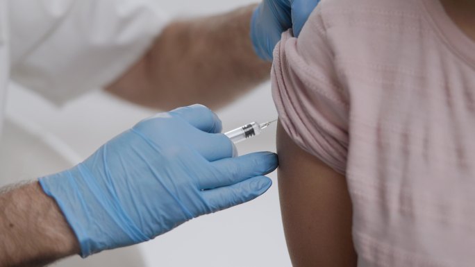 医生给年轻女性注射流感疫苗
