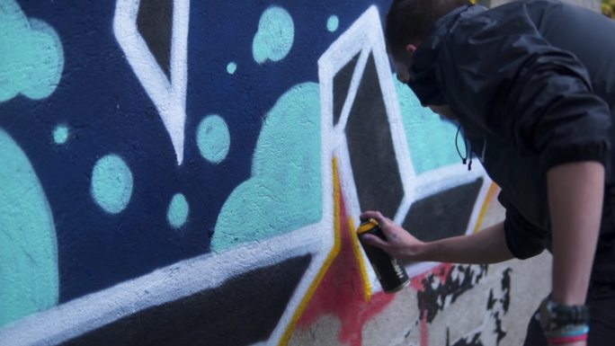 男子在墙上涂鸦街头艺术