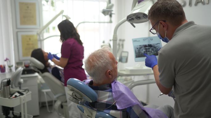 牙医向患者展示牙科X光图像