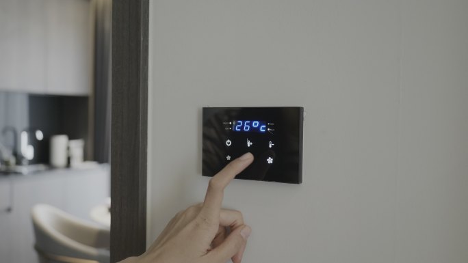 女性使用智能家居控制器设置室温