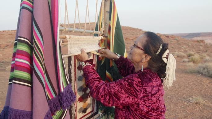 老年妇女正在用老式织布机制作传统毯子