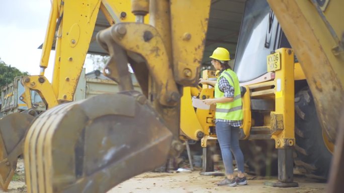 女工程师站在挖掘机旁