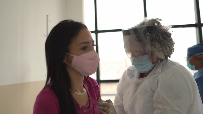 正在接种疫苗的年轻女子—戴口罩