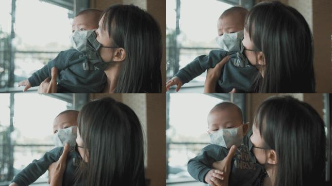 妈妈抱着儿子疫情宝宝戴口罩的婴儿疫情影响