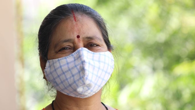 一位年长的女士戴着口罩以防病毒