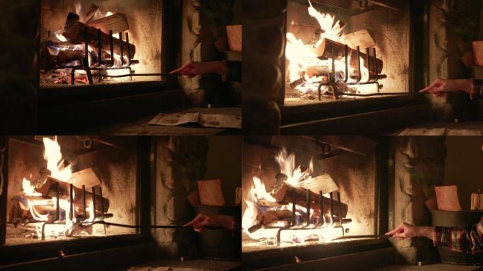 妇女在冬季小屋的壁炉里燃烧木头