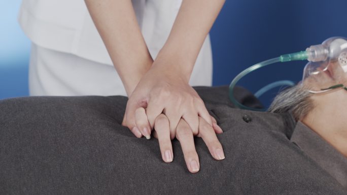 护士正在帮助病人用手按压胸部