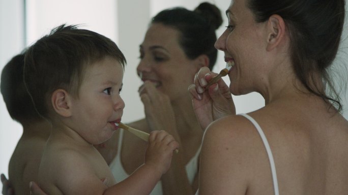 教儿子刷牙的年轻女子