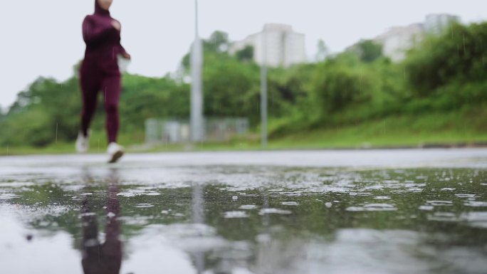 女运动员在雨中在街上慢跑