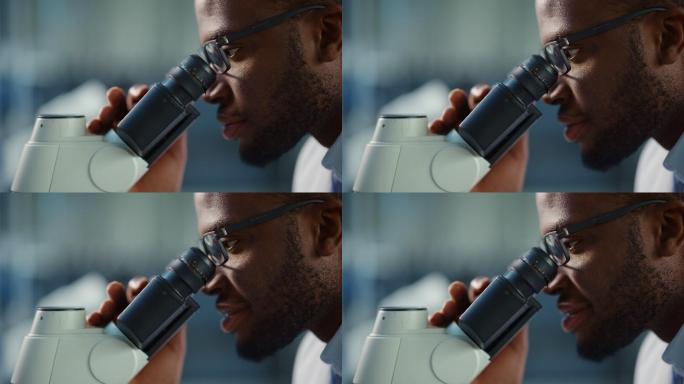 男性科学家看着显微镜的特写镜头
