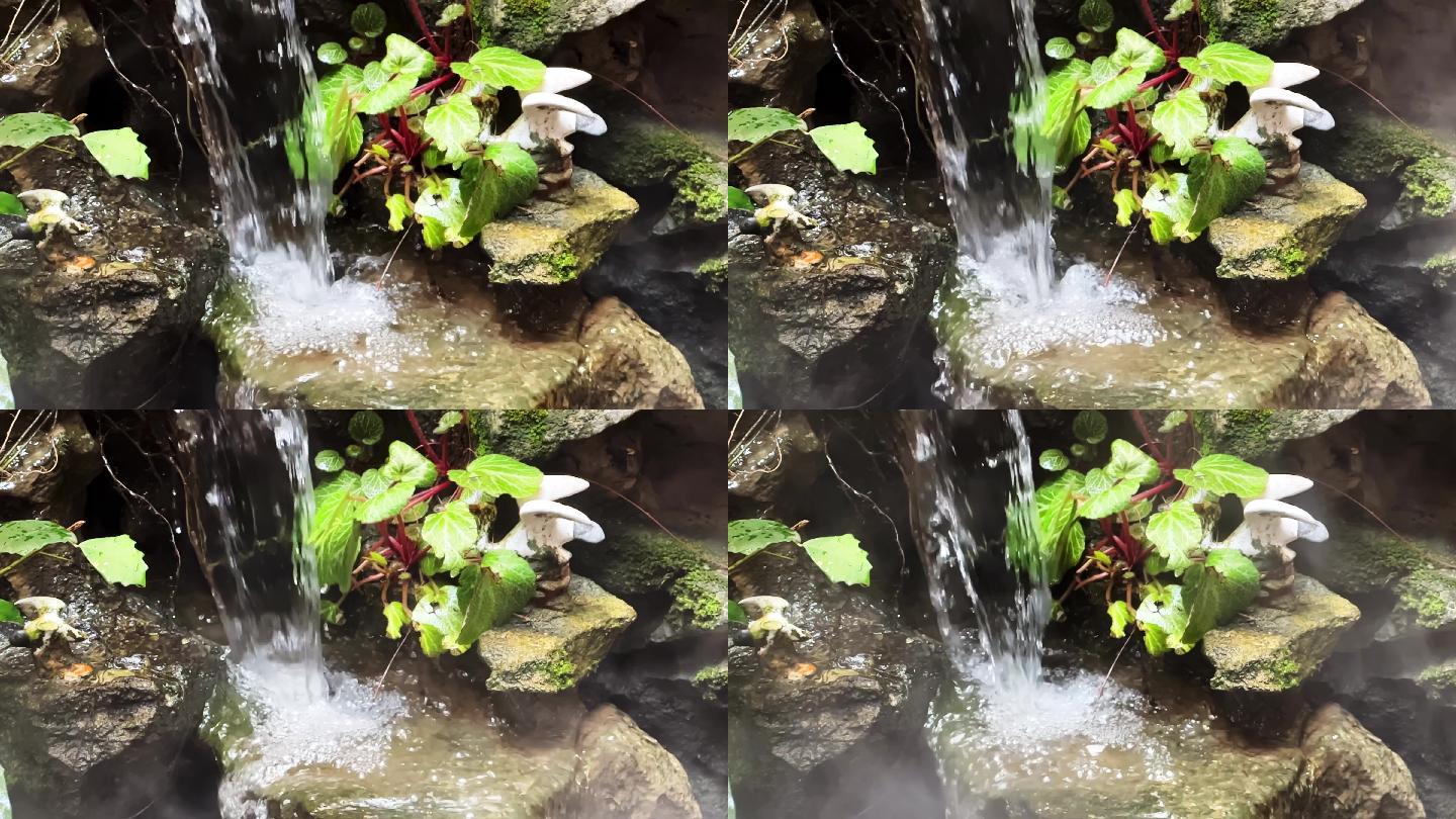 一座水池假山景观的流水慢动作视频
