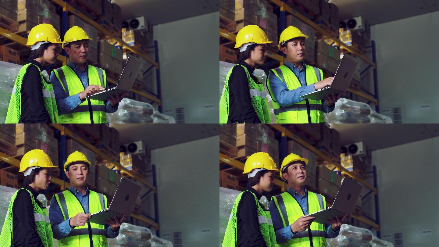 两名仓库工人正在检查笔记本电脑上的信息。
