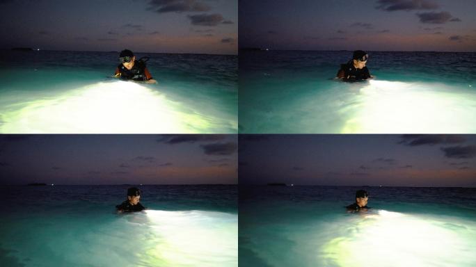潜水员在黄昏时用手电筒在水中搜寻